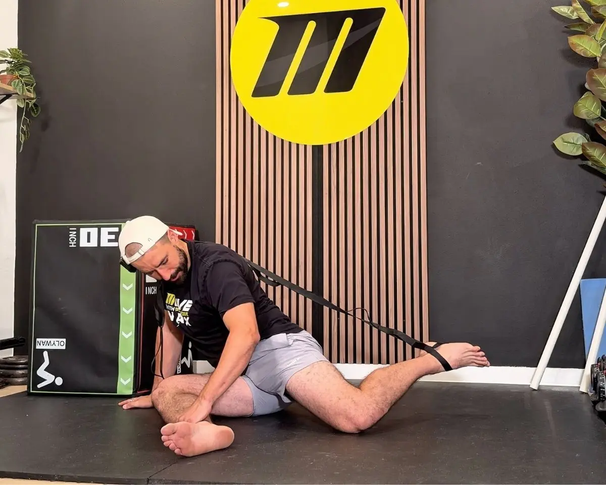 Brian Murray working hip end range with a strap at the Motive Training studio