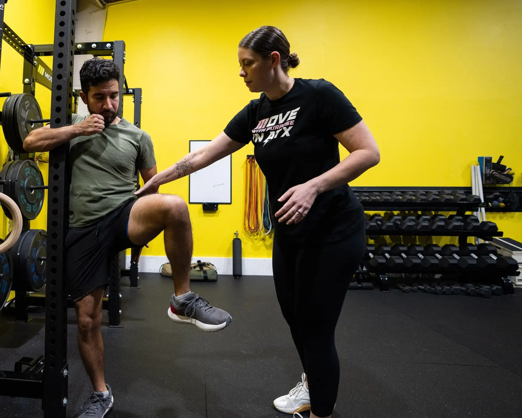 Coach guiding a client's hip through its range of motion at Motive Training in South Austin