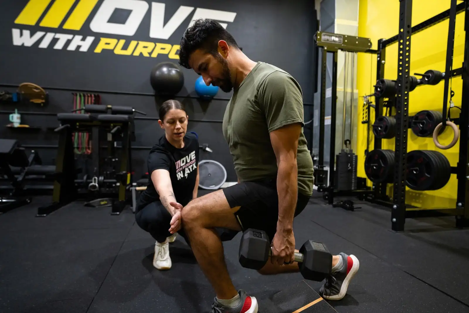 Coach cueing a client through a dumbbell split squat at Motive Training in South Austin